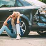 girl sits on the road, near the car which ran into accident